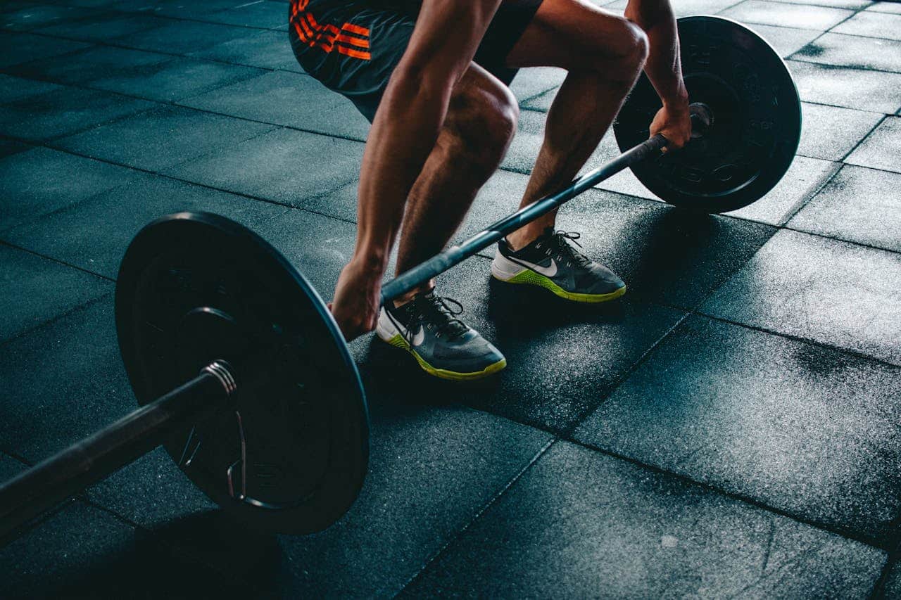 hero-about Man performing a deadlift exercise in a gym, demonstrating strength and fitness.